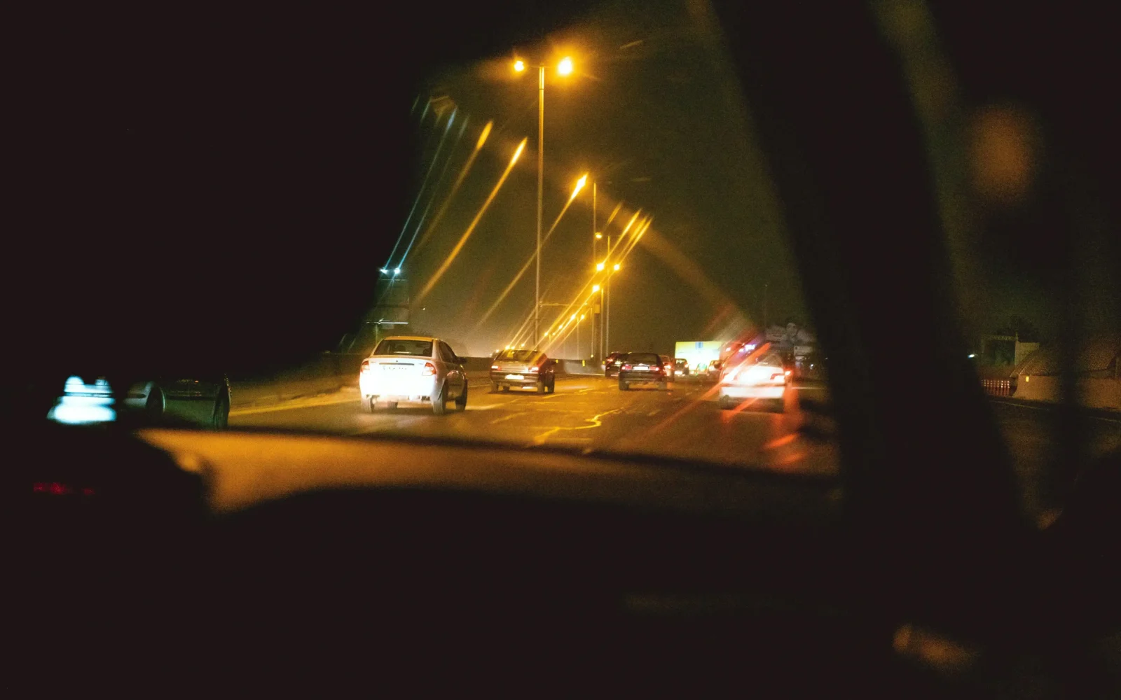 View from inside a car's interior looking out at a freeway with surrounding traffic